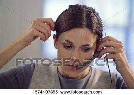 Close-up of a businesswoman adjusting her headset View Large Photo Image Stock Photography - Close-up of a businesswoman adjusting her headset. Fotosearch