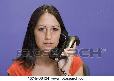 Close-up of a businesswoman holding a telephone receiver in an office View Large Photo Image Picture - Close-up of a businesswoman holding a telephone receiver in an office. Fotosearch