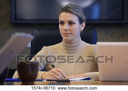 Stock Image - Close-up of a businesswoman sitting in a conference room. Fotosearch