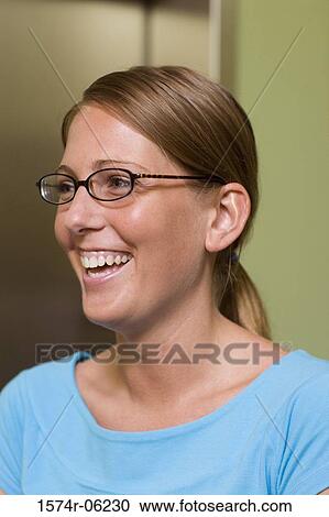 Stock Image - Close-up of a businesswoman smiling in an office. Fotosearch