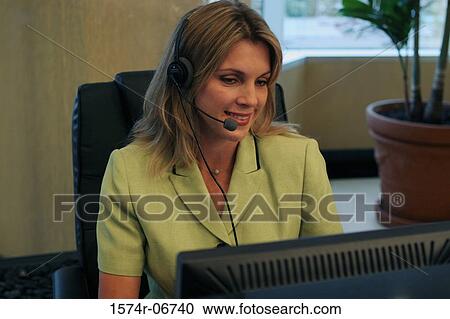 Close-up of a businesswoman wearing a headset working on a computer View Large Photo Image Stock Image - Close-up of a businesswoman wearing a headset working on a computer. Fotosearch