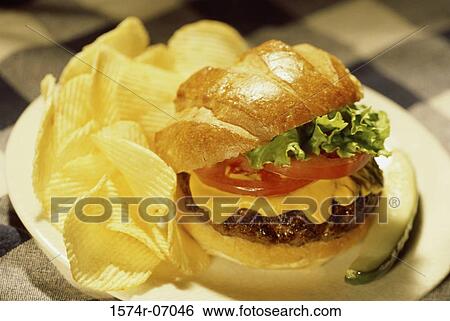 Close-up of a cheeseburger with chips View Large Photo Image Stock Photograph - Close-up of a cheeseburger with chips. Fotosearch