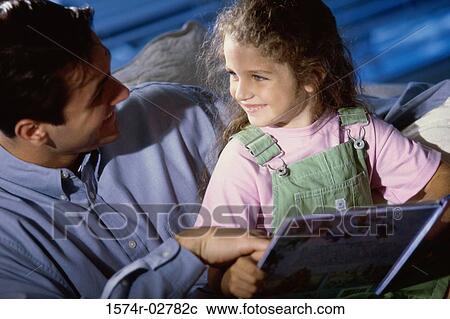 Close-up of a father and his daughter reading a book View Large Photo Image Stock Image - Close-up of a father and his daughter reading a book. Fotosearch