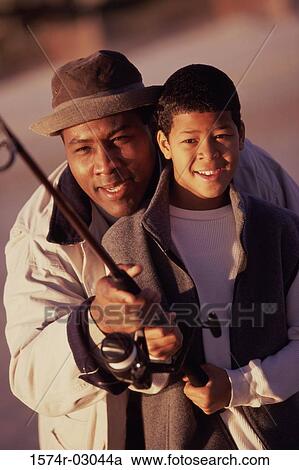Close-up of a father teaching his son fishing View Large Photo Image Stock Image - Close-up of a father teaching his son fishing. Fotosearch
