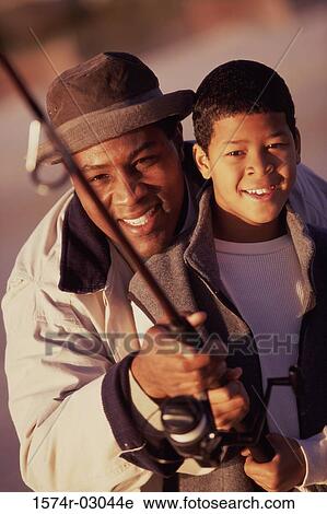 Close-up of a father teaching his son fishing View Large Photo Image Stock Image - Close-up of a father teaching his son fishing. Fotosearch