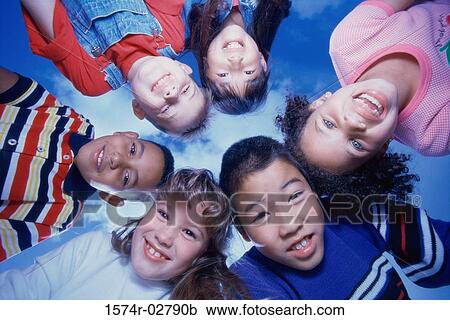 Stock Image - Close-up of a group of children in a huddle. Fotosearch