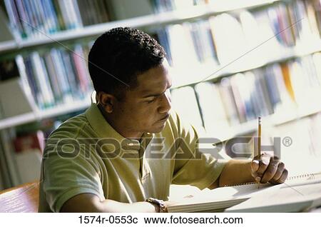 Stock Image - Close-up of a mid adult man writing in a notebook. Fotosearch
