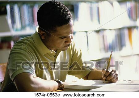 Stock Image - Close-up of a mid adult man writing in a notebook. Fotosearch