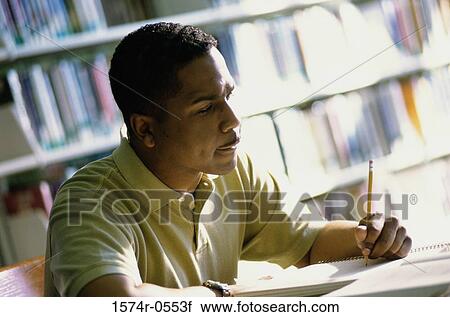 Stock Image - Close-up of a mid adult man writing in a notebook. Fotosearch