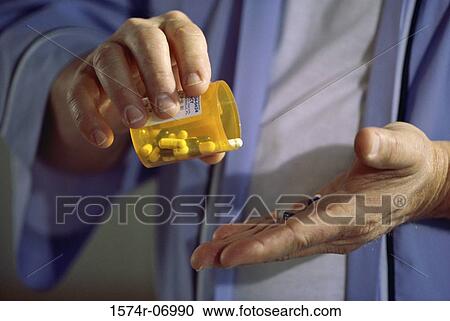 Close-up of a person holding a bottle of pills View Large Photo Image Stock Image - Close-up of a person holding a bottle of pills. Fotosearch