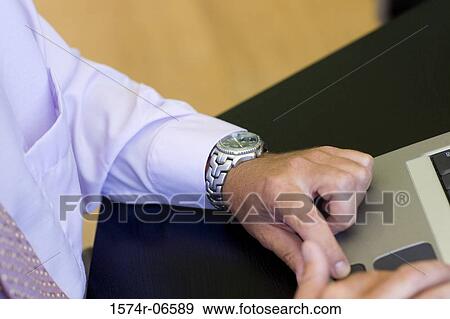 Stock Photo - Close-up of a person using a laptop in an office. Fotosearch
