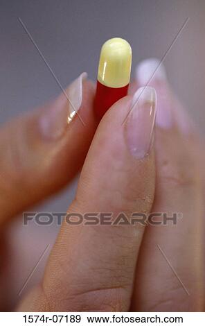Close-up of a person's hand holding a capsule View Large Photo Image Stock Photo - Close-up of a person's hand holding a capsule. Fotosearch