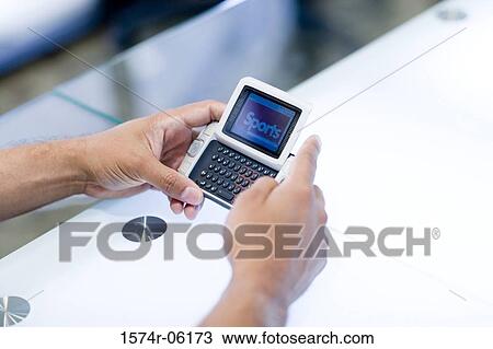 Stock Image - Close-up of a person's hands holding a hand held device. Fotosearch