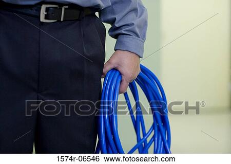 Stock Photograph - Close-up of a technician holding computer cables. Fotosearch