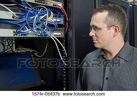 Stock Image - Close-up of a technician looking at a network server. Fotosearch