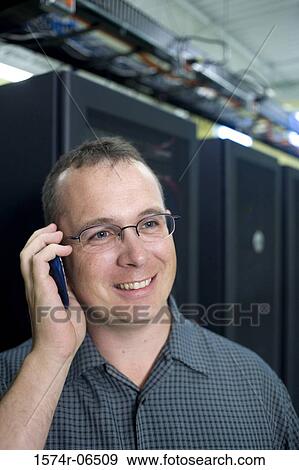 Close-up of a technician talking on a mobile phone in a server room View Large Photo Image Stock Photo - Close-up of a technician talking on a mobile phone in a server room. Fotosearch