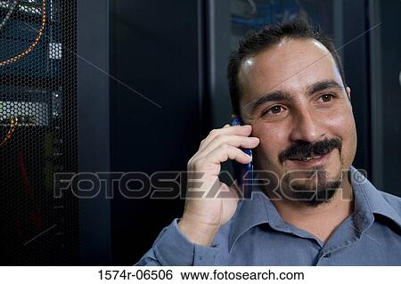 Close-up of a technician talking on a mobile phone View Large Photo Image Stock Photograph - Close-up of a technician talking on a mobile phone. Fotosearch