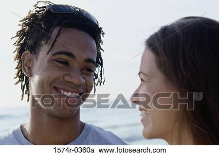 Close-up of a teenage couple looking at each other View Large Photo Image Stock Image - Close-up of a teenage couple looking at each other. Fotosearch