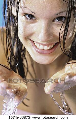 Close-up of a young woman washing her face View Large Photo Image Stock Image - Close-up of a young woman washing her face. Fotosearch
