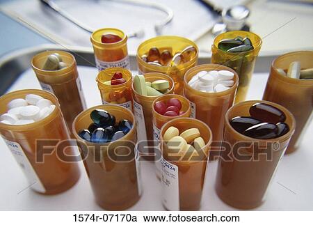 Stock Image - Close-up of an assortment of tablets and capsules in vials. Fotosearch
