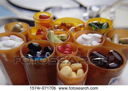 Stock Image - Close-up of an assortment of tablets and capsules in vials. Fotosearch