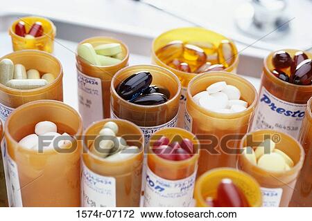 Stock Image - Close-up of an assortment of tablets and capsules in vials. Fotosearch