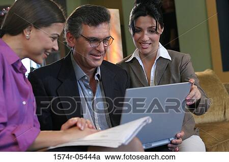 Close-up of two businesswomen sitting with a businessman View Large Photo Image Stock Image - Close-up of two businesswomen sitting with a businessman. Fotosearch