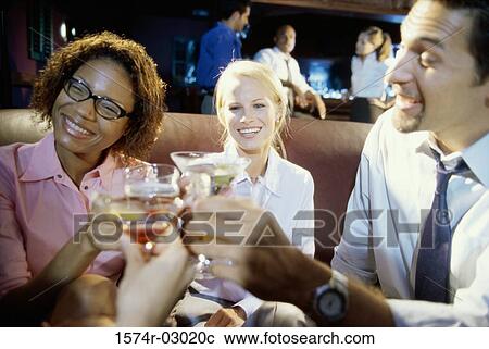 Close-up of two young women and young man toasting with glasses View Large Photo Image Stock Image - Close-up of two young women and young man toasting with glasses. Fotosearch