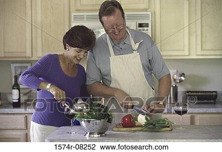 Couple chopping vegetables in a kitchen View Large Photo Image Stock Image - Couple chopping vegetables in a kitchen. Fotosearch