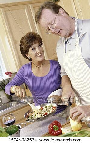 Couple cooking together in a kitchen View Large Photo Image Stock Image - Couple cooking together in a kitchen. Fotosearch