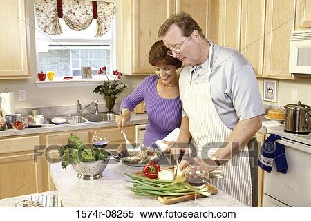 Stock Photography - Couple cooking together in a kitchen. Fotosearch