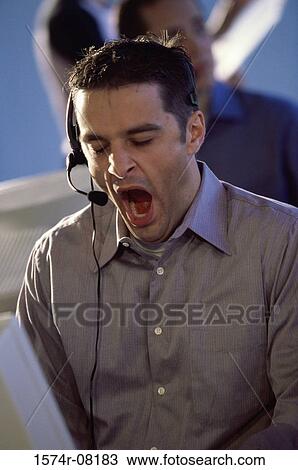 Customer service representative wearing a headset yawning View Large Photo Image Stock Image - Customer service representative wearing a headset yawning. Fotosearch