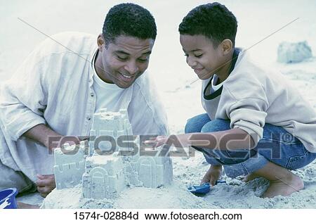 Father and his son building sand castles on the beach View Large Photo Image Stock Image - Father and his son building sand castles on the beach. Fotosearch