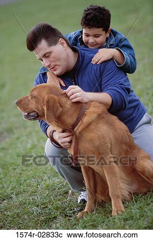 Stock Image - Father and his son with their dog. Fotosearch