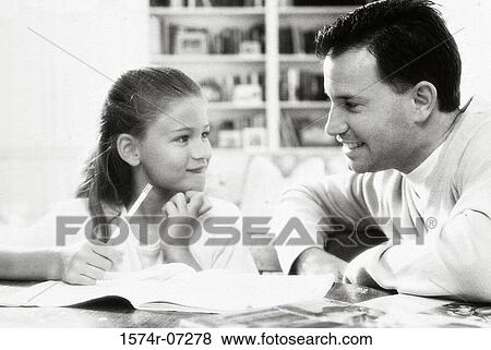 Stock Photo - Father assisting his daughter with her homework. Fotosearch
