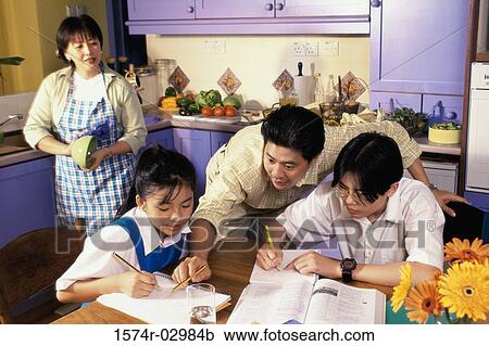 Stock Image - Father helping his son and daughter with their homework. Fotosearch