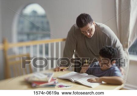 Stock Image - Father helping his son with homework. Fotosearch