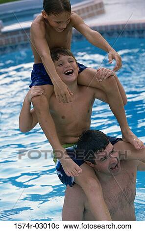 Father in a swimming pool with his two sons sitting on his shoulders View Large Photo Image Stock Image - Father in a swimming pool with his two sons sitting on his shoulders. Fotosearch