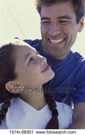 Stock Image - Father looking at his daughter. Fotosearch