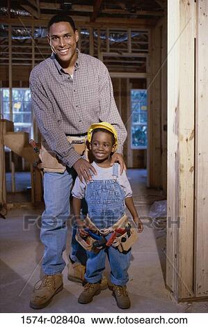 Stock Image - Father standing with his son at a construction site. Fotosearch
