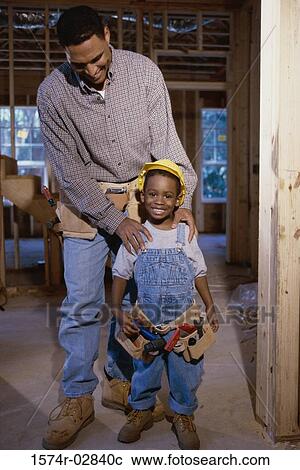 Father standing with his son at a construction site View Large Photo Image Stock Image - Father standing with his son at a construction site. Fotosearch