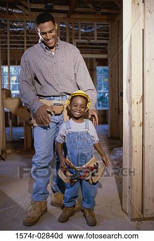 Stock Image - Father standing with his son at a construction site. Fotosearch