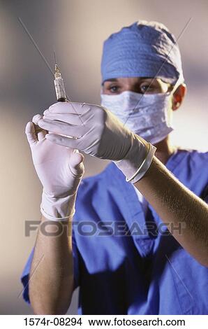 Female doctor holding a syringe View Large Photo Image Picture - Female doctor holding a syringe. Fotosearch