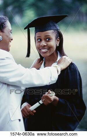 Female graduate standing with her mother View Large Photo Image Stock Image - Female graduate standing with her mother. Fotosearch