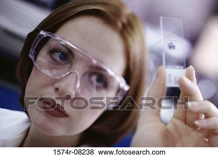 Stock Photo - Female researcher holding a slide. Fotosearch