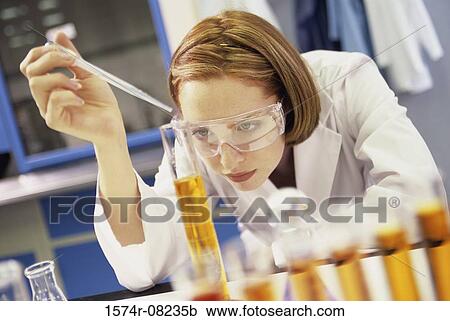 Stock Image - Female researcher working with chemicals. Fotosearch