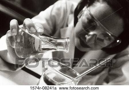 Stock Image - Female researcher working with chemicals. Fotosearch