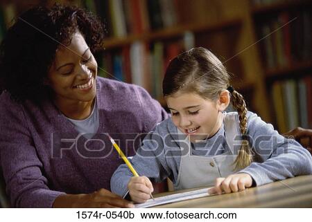 Female teacher teaching a girl View Large Photo Image Stock Image - Female teacher teaching a girl. Fotosearch