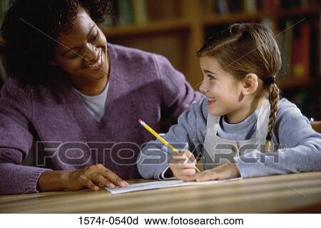 Female teacher teaching a girl View Large Photo Image Stock Image - Female teacher teaching a girl. Fotosearch