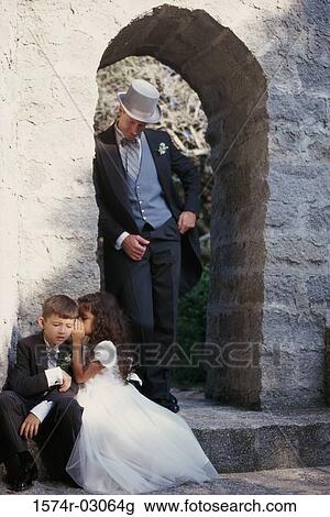 Stock Image - Flower girl whispering to a ring bearer. Fotosearch